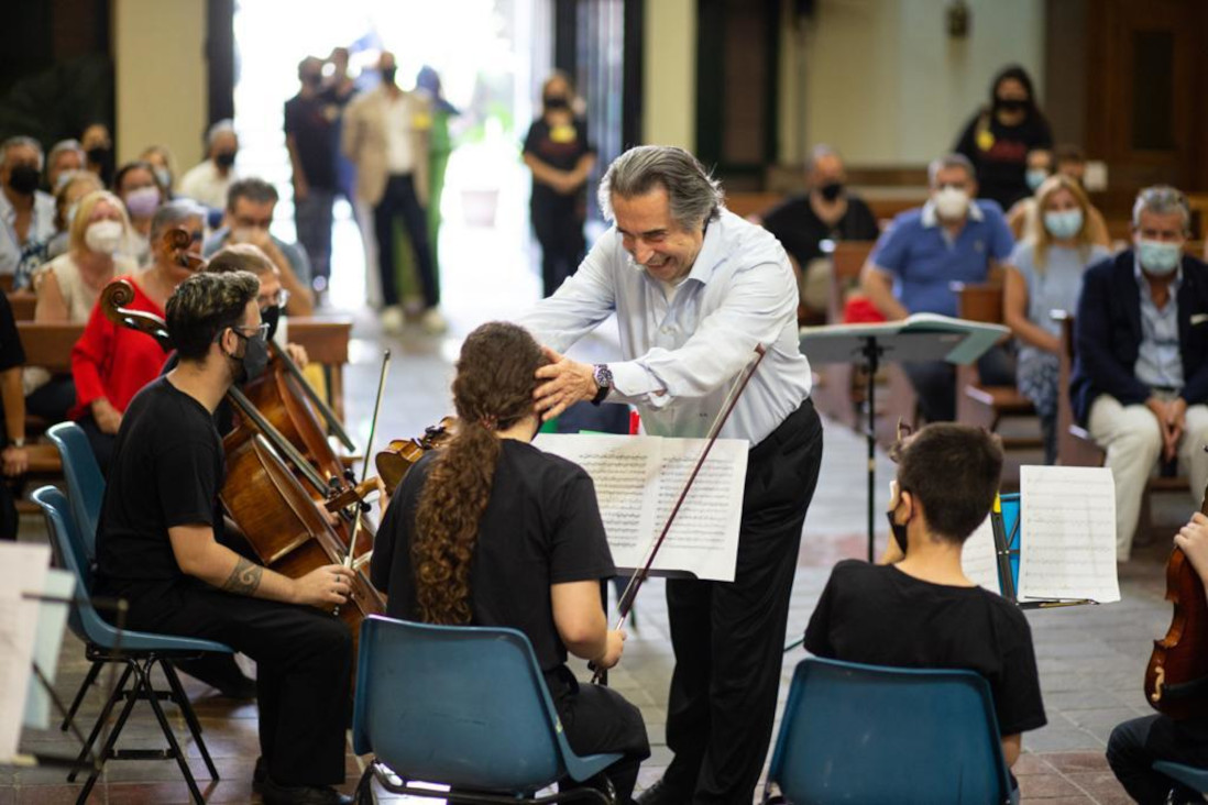 Il Maestro Riccardo Muti scherza con alcuni giovani musicisti dell'orchesta Musica Libera Tutti